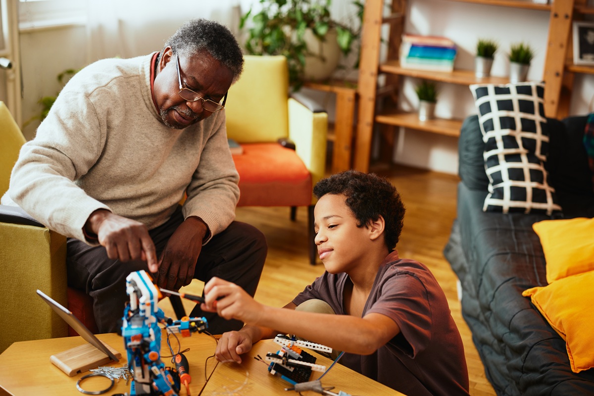 A grandad and grandson making a robot together at home.